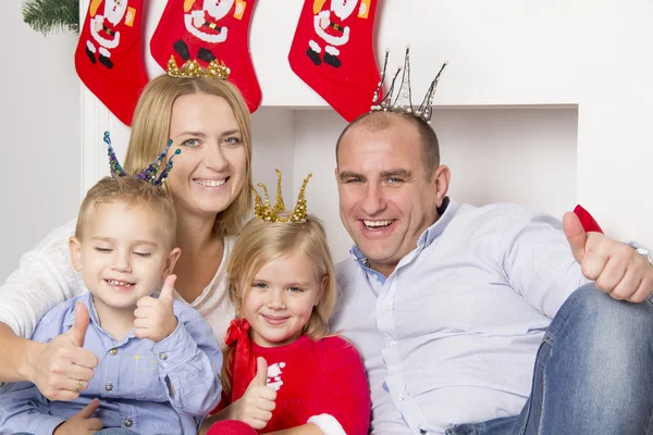 Familia sentada cerca de la chimenea de Navidad — Foto de Stock