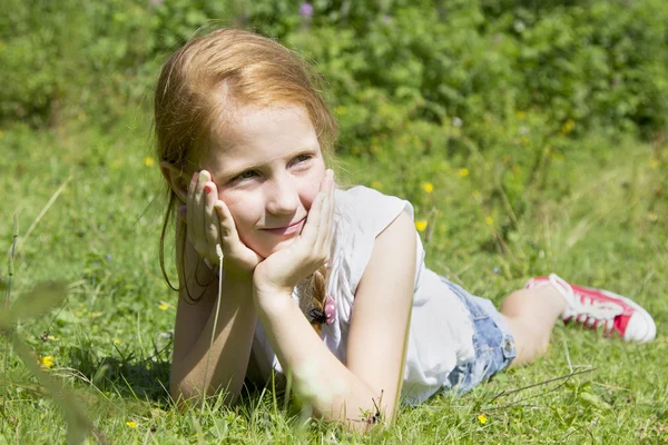 Beautiful girl sitting on the meadow — Stock Photo, Image