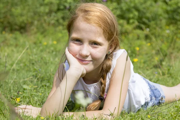 Mooi meisje, zittend op de weide — Stockfoto