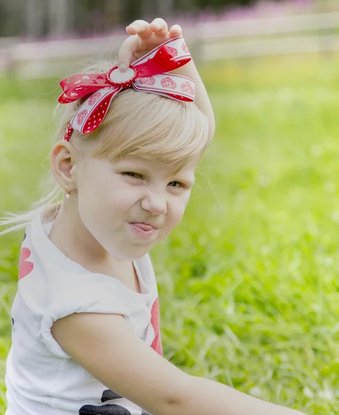 Sorridente bambina mostrando lingua — Foto Stock