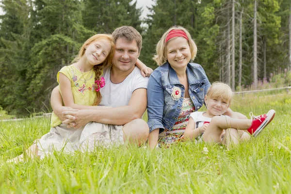 Familjen sitter på ängen — Stockfoto