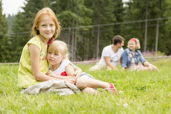 Sisters sitting on the meadow — Stock Photo, Image