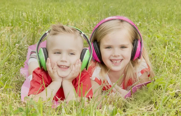 Дівчина з хлопчиком в навушниках слухає музику — стокове фото