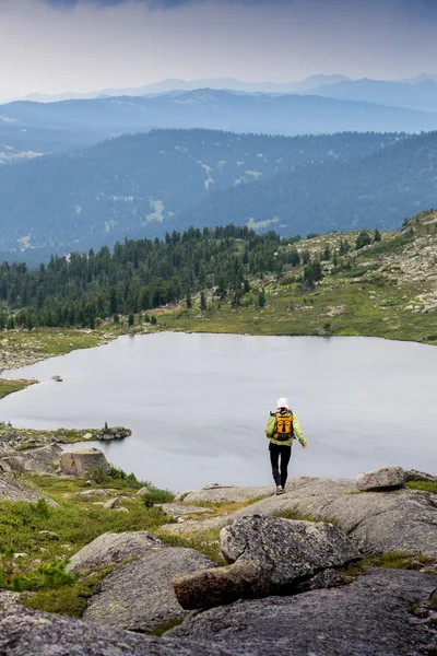 Sendero corriendo mujer a través del país en las montañas en verano hermoso día — Foto de Stock