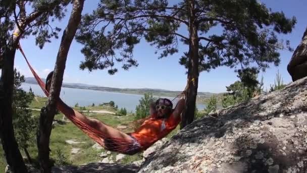 Homem relaxante na rede em um belo dia . — Vídeo de Stock