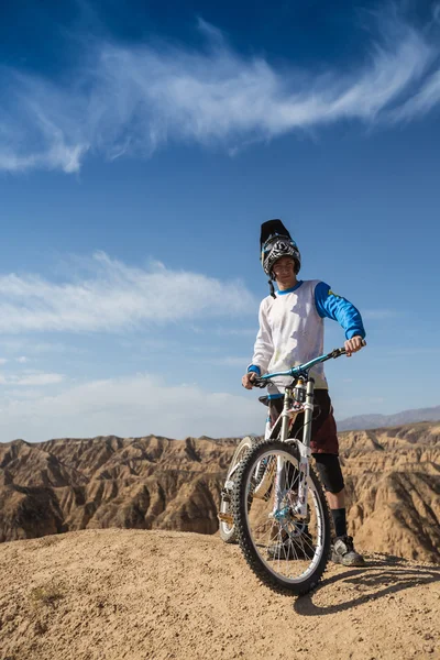 Hombre joven en una bicicleta de montaña montar y relajarse en el cañón de Charyn, Kazajstán — Foto de Stock