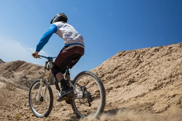 Hombre joven en una bicicleta de montaña montar y relajarse en el cañón de Charyn, Kazajstán — Foto de Stock