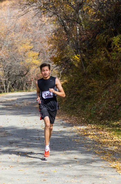 ALMATY, ALMATY DISTRICT, KAZAKHSTAN-OCTOBER 10, 2015: Man runs for fun and take part in a sporting event, on the competition trail running Alatau Train Run 2016, in the national reserve Yunats Lakes — стоковое фото