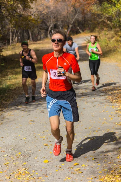 ALMATY, ALMATY DISTRICT, KAZAKHSTAN-OCTUBRE 10, 2015: El hombre corre por diversión y participa en un evento deportivo, en el sendero de competición que corre Alatau Train Run 2016, en la reserva nacional Yunats Lakes — Foto de Stock