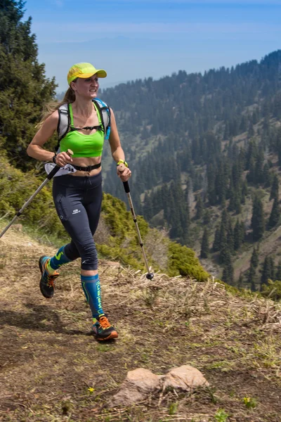 ALMATY, ALMATY DISTRIKT, KAZAKHSTAN - 22 DE MAYO DE 2016: Competencia abierta SKY RANNING 2016 celebrada en el desfiladero de Eliksay. Una chica corre hasta la montaña llamada Bukreeva participando en la competencia —  Fotos de Stock