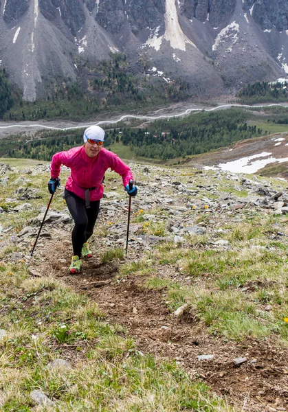 Donna che corre in montagna sotto la luce del sole . — Foto Stock