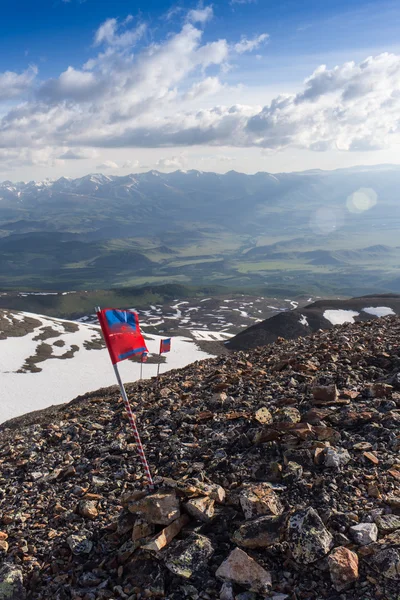 Красный флаг на фоне гор — стоковое фото