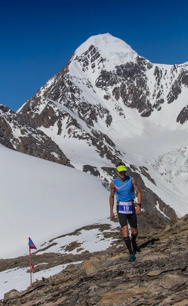 L'uomo corre su una strada rurale durante il tramonto in montagna — Foto Stock