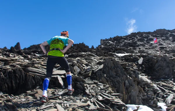 L'uomo corre su una strada rurale durante il tramonto in montagna — Foto Stock