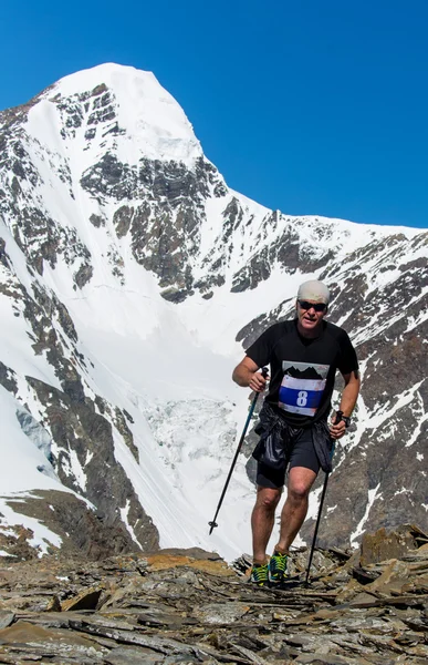 L'uomo corre su una strada rurale durante il tramonto in montagna — Foto Stock