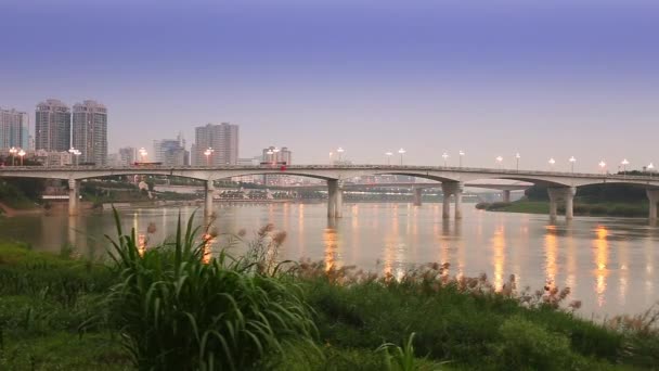 Parejas caminan a través de un puente decorado con linternas rojas por la noche — Vídeos de Stock