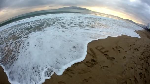 Inscription "love" on the sand washes wave — Stock Video