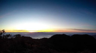 Parlak Zirvesi şafak akan bulut dalgalar, kırmızı güneş disk zaman atlamalı yukarıda