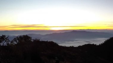 Parlak Zirvesi şafak akan bulut dalgalar, kırmızı güneş disk zaman atlamalı yukarıda