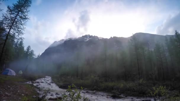 Pequeña tienda de campaña es plantada por un arroyo de montaña en el bosque en otoño con follaje de otoño . — Vídeos de Stock