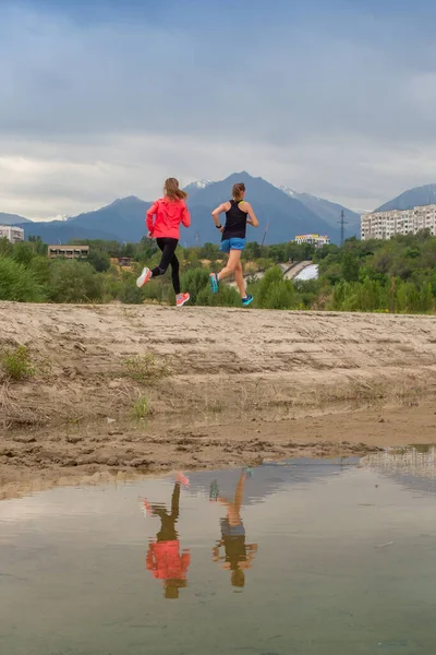 Due belle ragazze sono venute al parco della città in nuovo abbigliamento sportivo per andare a fare jogging. — Foto Stock