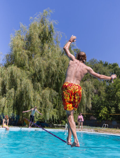 People walk on the sling over the water