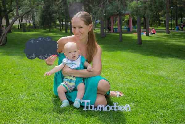 Madre joven caminando con su bebé en el parque — Foto de Stock