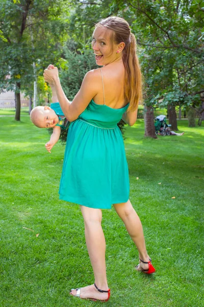 Madre joven caminando con su bebé en el parque — Foto de Stock