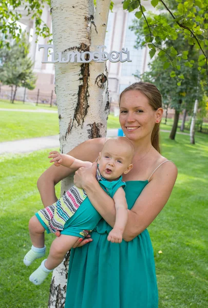 Junge Mutter spaziert mit ihrem Baby im Park — Stockfoto