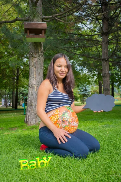 Gravid flicka promenader i parken — Stockfoto