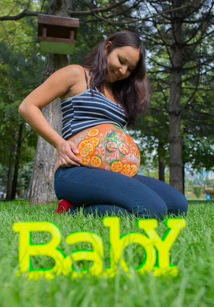 Chica embarazada caminando en parque — Foto de Stock