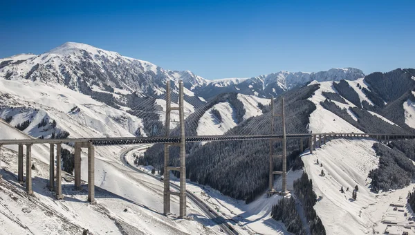 Huge and beautiful road bridge in snowy mountains — Stock Photo, Image