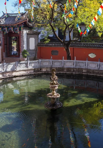 Beautiful Chinese garden with a pond and flags — Stock Photo, Image