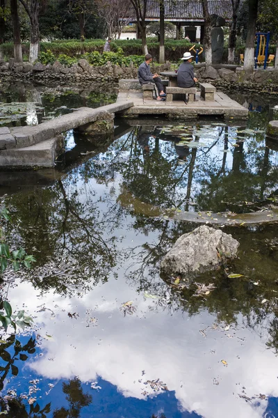 Hermoso jardín chino con un estanque y banderas — Foto de Stock