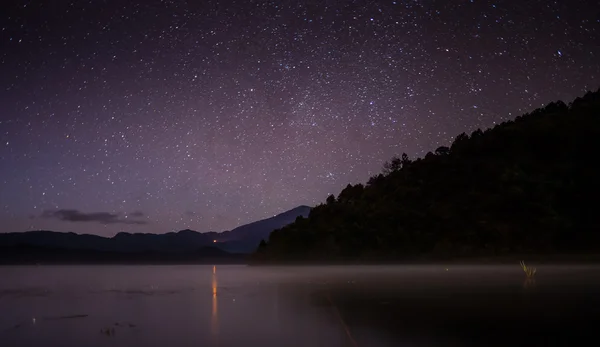 Lago tranquilo bajo el cielo estrellado — Foto de Stock