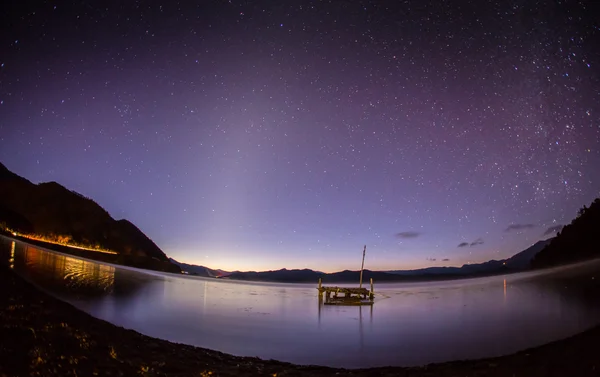 Lago tranquilo bajo el cielo estrellado — Foto de Stock
