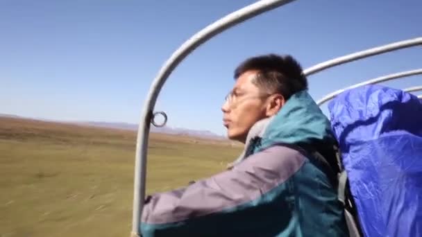 Um homem olha para a distância enquanto cavalga — Vídeo de Stock