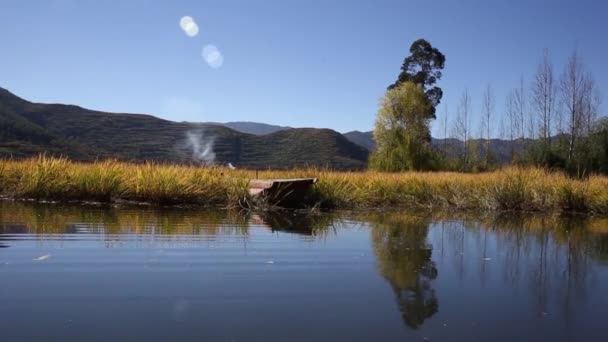 Озеро с лодкой и деревьями — стоковое видео