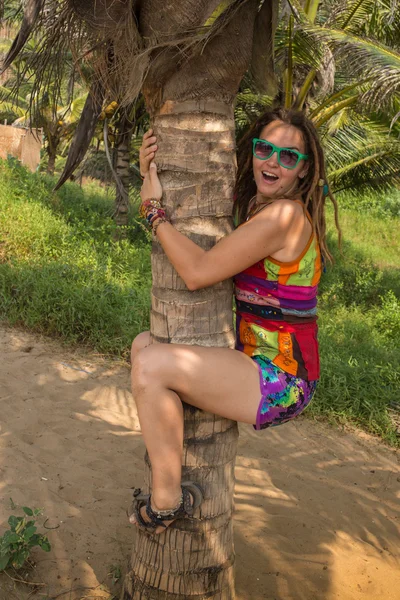Kobieta na plaży siedzi palmy — Zdjęcie stockowe