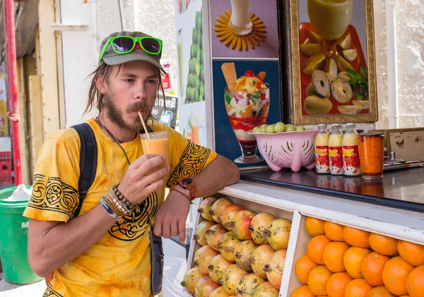Portrait of a young man who is drinking juice — Stock Photo, Image