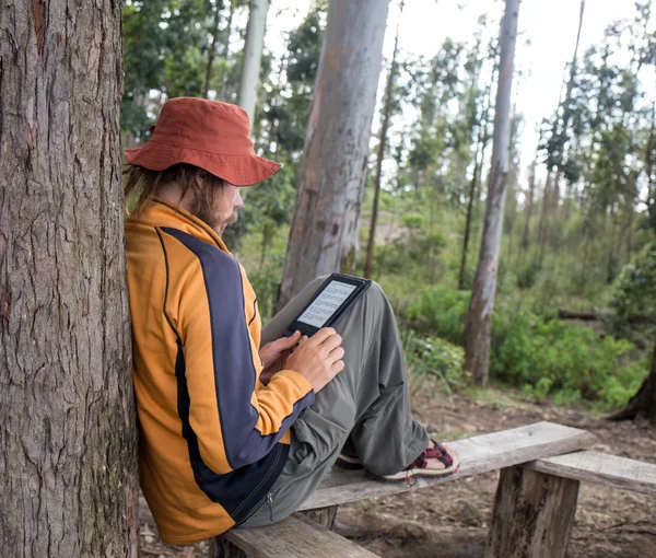 Giovane viaggiatore con zaino lettura libro — Foto Stock