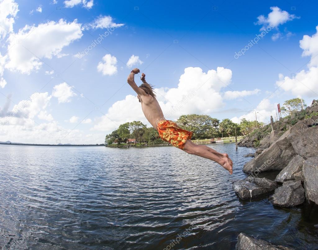 Teenage boy jumping in the river 