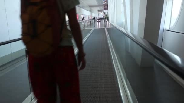 Silueta de familia joven con equipaje caminando en el aeropuerto, chica apuntando a la ventana — Vídeo de stock