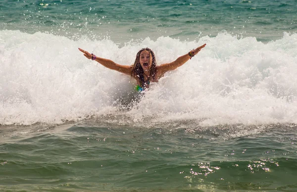 Fille rire et pleurer dans la pulvérisation des vagues à la mer par une journée ensoleillée — Photo