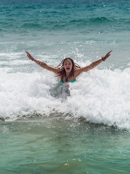 Dívka, směje se a pláče ve spreji vln na moři na slunečný den — Stock fotografie