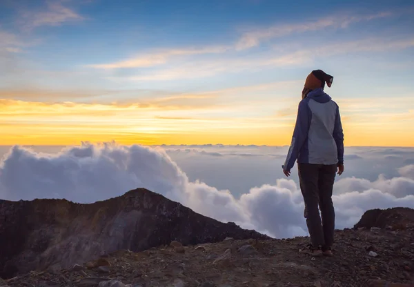 Menina feliz pulando na montanha na hora do pôr do sol — Fotografia de Stock