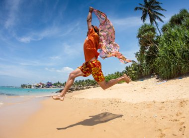Koşma ve atlama ile renkli bir tisue Beach güzel adam