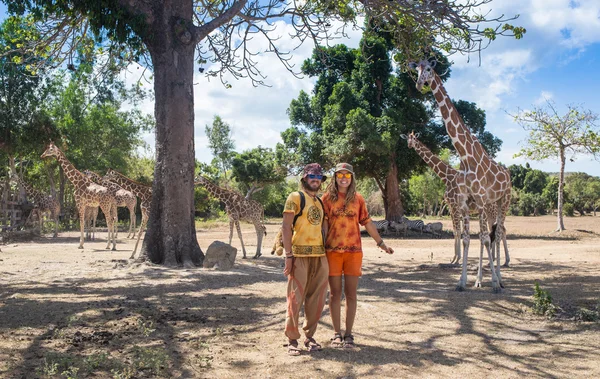 Šťastná rodina krmení žirafa během cesty do města zoo v horkém letním dni — Stock fotografie