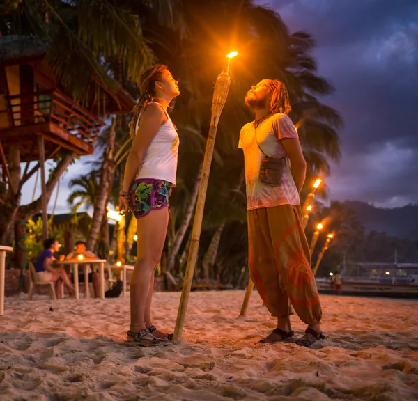 Photo tonique rouge d'un couple sur une plage tropicale au coucher du soleil — Photo