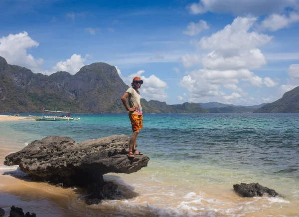 젊은이 해안선에 서 서 하 고 바다 위에 아름 다운 석양을 즐길. — 스톡 사진